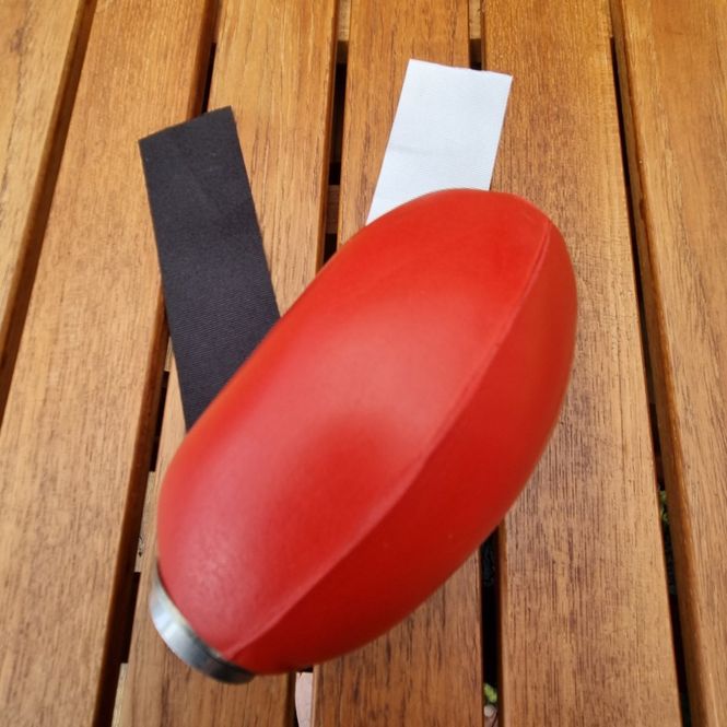 Huvudbild Dummy till apportkastare Röd plast med svart och vit streamer Längd ca 12,5 cm Diameter ca 7,5 cm  Sporting Saint